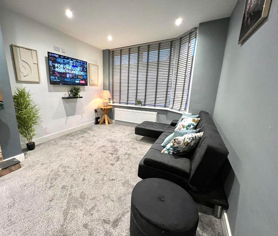 uma sala de estar com um sofá e uma televisão de ecrã plano em Opple house em Coventry