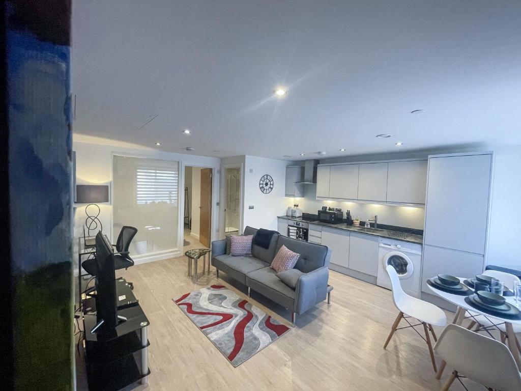 Il comprend un salon avec un canapé et une cuisine. dans l'établissement Ground Floor One Bedroom Flat Centre of Woking with Off Street Parking, à Woking