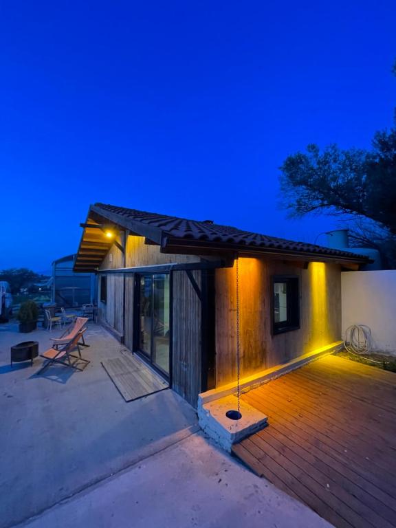 una casa con terraza de madera por la noche en Gökler Çiftliğinde Ekolojik Tatil, en Foca