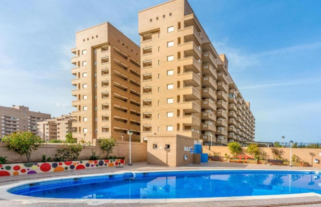 a swimming pool in front of two tall buildings at Jardines del Mar in Oropesa del Mar