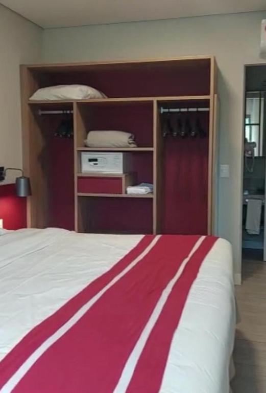 - une chambre dotée d'un lit avec une couverture rouge et blanche dans l'établissement Adriana Rinaldi Gonçalves, à Angra dos Reis