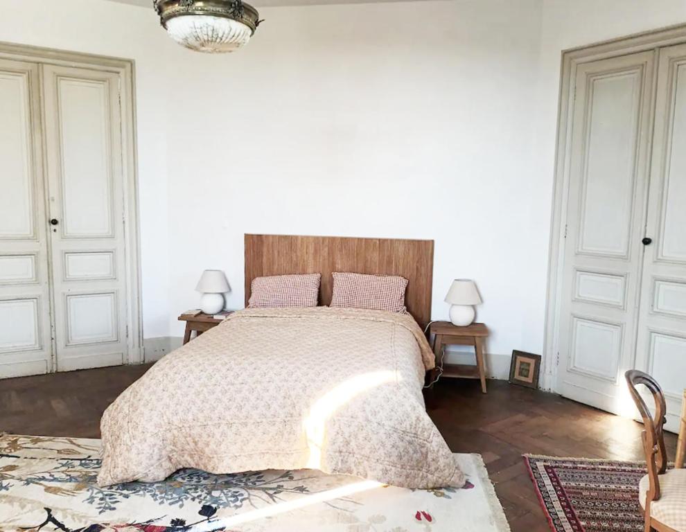 - une chambre avec un grand lit et une tête de lit en bois dans l'établissement Grande chambre avec SDB privée, à Bazas
