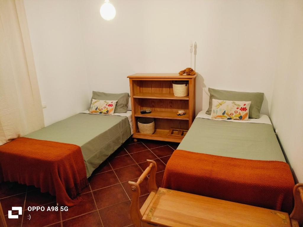 Habitación con 2 camas y estante para libros en Habitación acogedora y sencilla, en El Puerto de Santa María