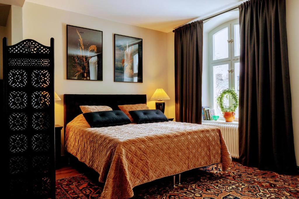 een slaapkamer met een bed en een groot raam bij White Brig Guesthouse in Hudiksvall