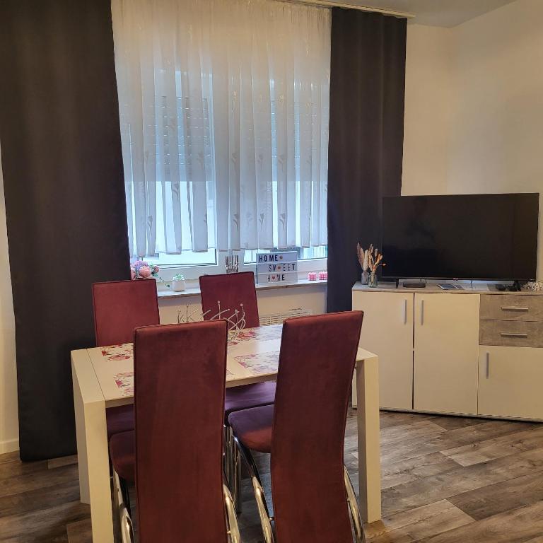 a dining room with a table with chairs and a television at Gemütliche Appartement in Bad Oeynhausen