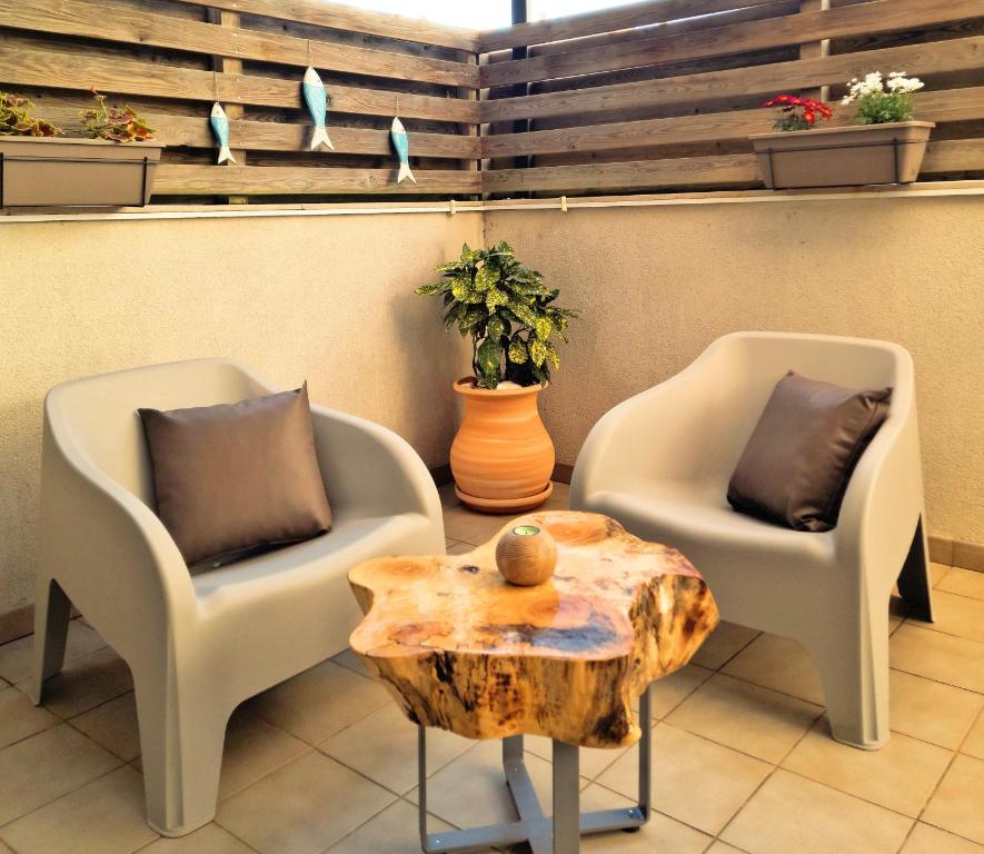 dwa krzesła i stolik kawowy z pniem drzewa w obiekcie Apartamento Lliris Sol w mieście L'Estartit