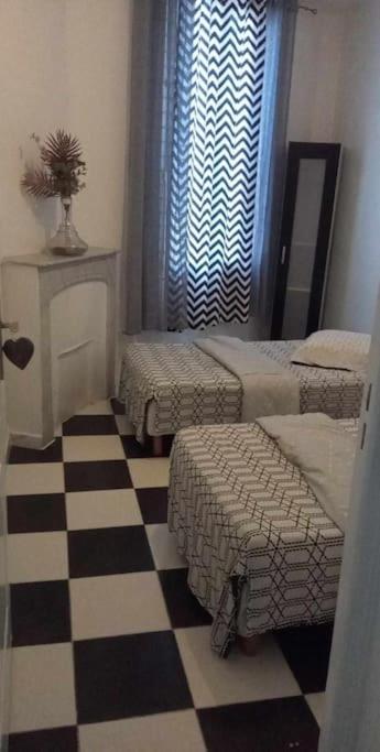 une chambre avec un sol en damier et une chambre avec un lit dans l'établissement appartement centre de Cannes, à Cannes