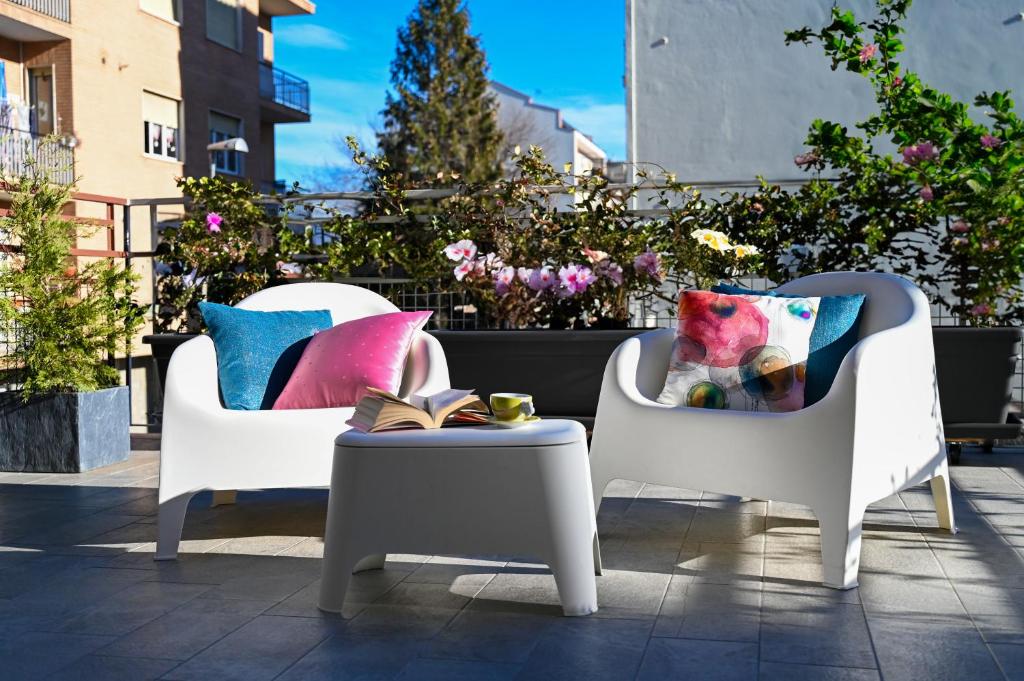- une terrasse avec 2 chaises et une table avec des oreillers dans l'établissement [La Casa DiLù] Moderno Trilocale e Ampio Terrazzo, à Grugliasco