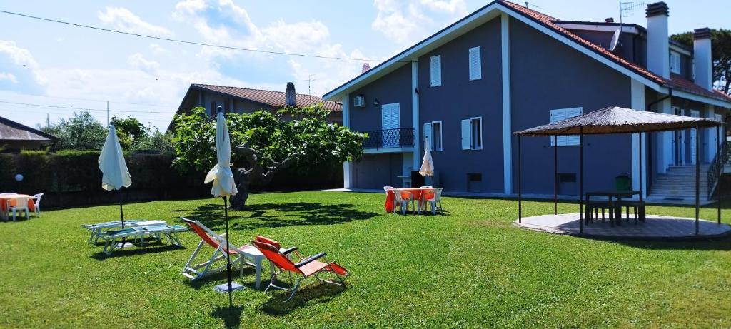 um quintal com cadeiras e guarda-sóis em frente a uma casa em Villa Matilde em Pescara