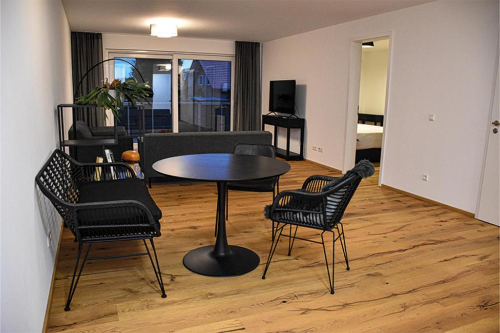 uma sala de estar com mesa e cadeiras em Ferienwohnung Bodenseeblick Nr 9 em Scheidegg
