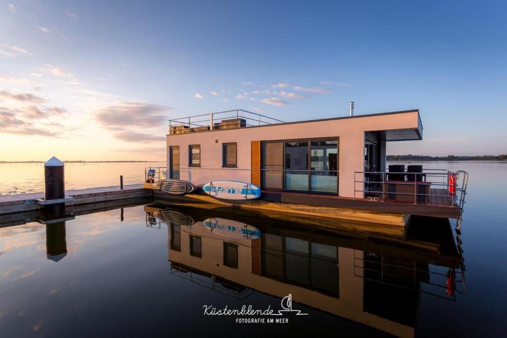 a house on a dock on a body of water at Hausboot Dory in Ribnitz-Damgarten