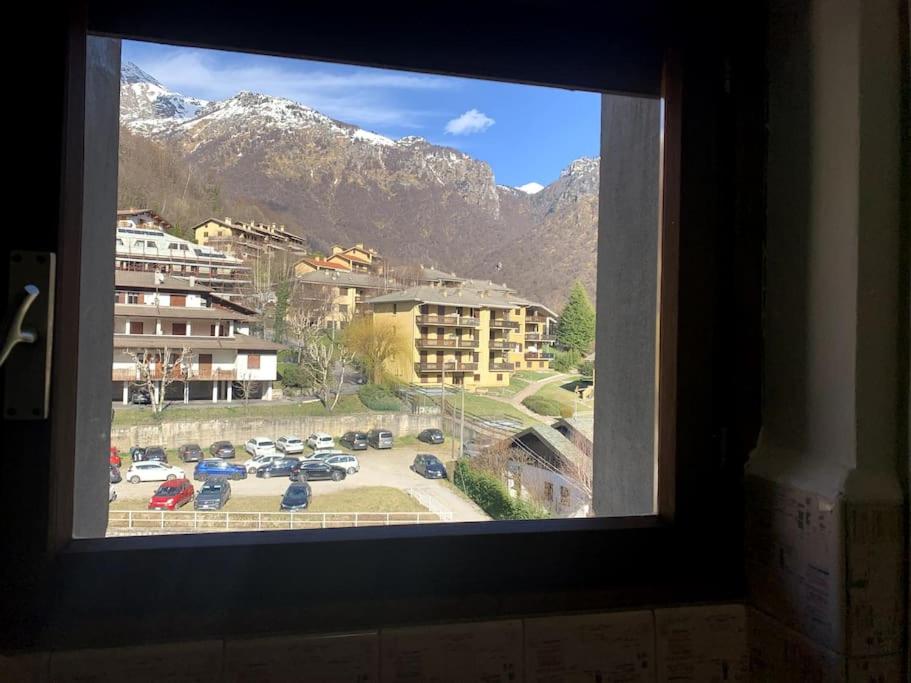 une fenêtre avec vue sur un parking dans l'établissement Appartamento nel cuore della Valsassina, à Moggio