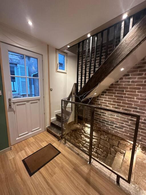 a living room with a staircase and a brick wall at Appartement F2 cosy en duplex Hyper Centre Bourgogne in Orléans