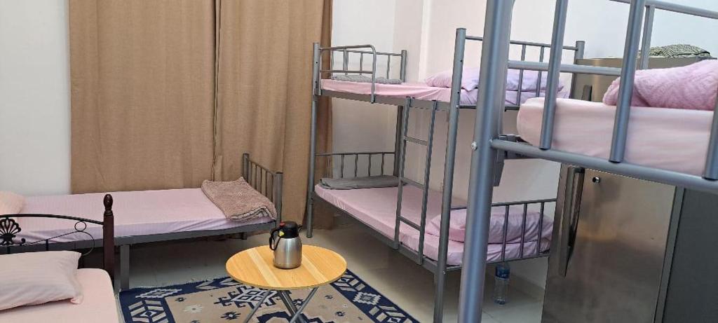 a room with two bunk beds and a table at MOHAMMAD HOSTEL in Muscat