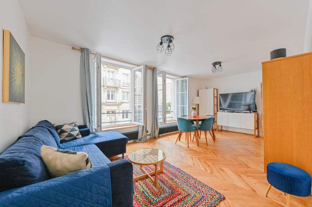 uma sala de estar com um sofá azul e uma mesa em PANTHEON em Paris