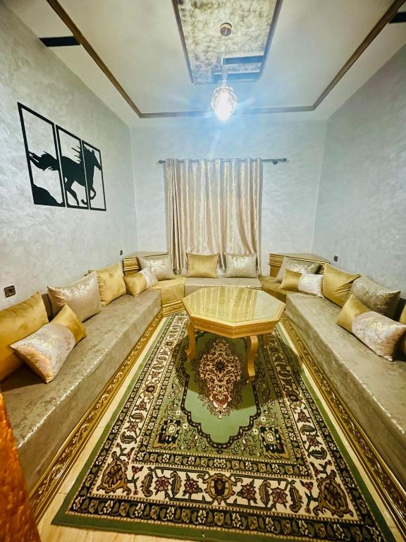 sala de estar con sofá y mesa en SAHARA APPARTEMENTS, en Merzouga