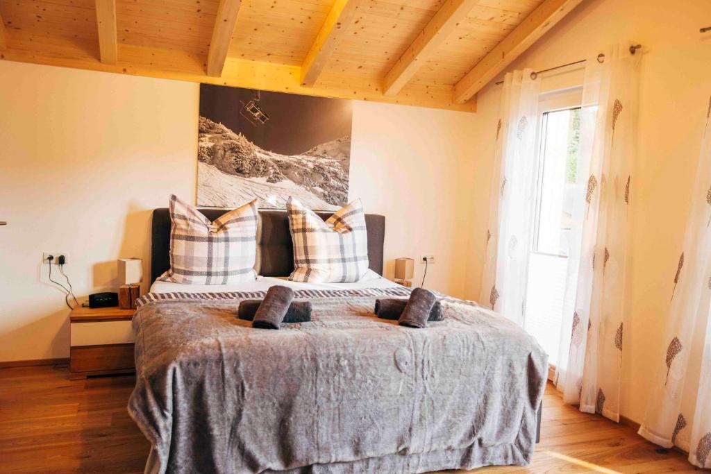 a bedroom with a large bed with two pillows at Haus Plattenbichlstraße - Ferienhäuser Alpenglück in Oberstdorf