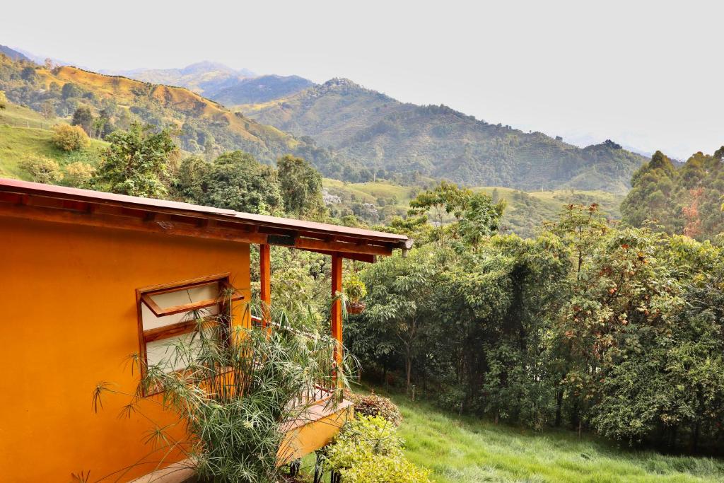 uma casa laranja numa colina com montanhas ao fundo em Ecoresort Gran Azul em Salento