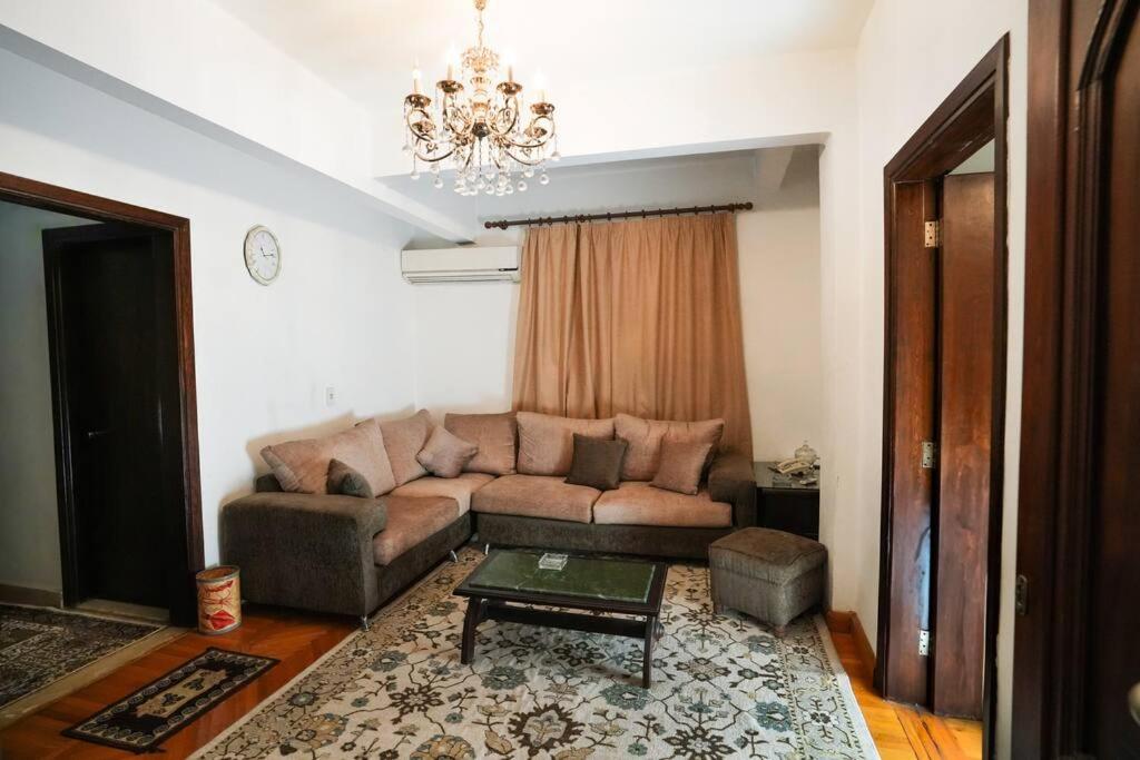 ein Wohnzimmer mit einem Sofa und einem Tisch in der Unterkunft Amazing Flat 9 mins to Airport at Heliopolis in Kairo