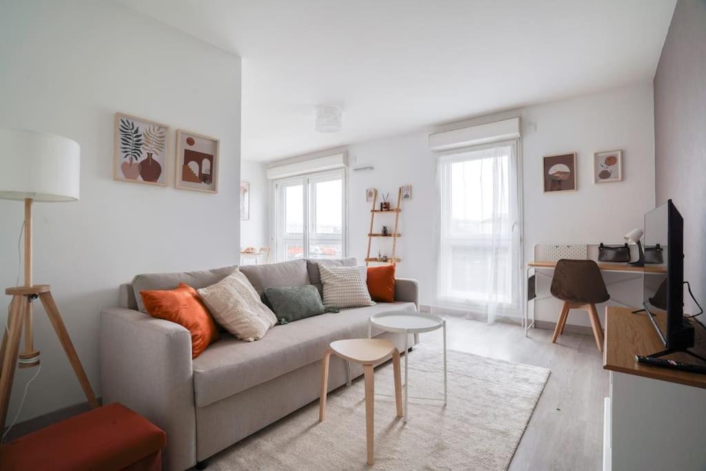 a living room with a couch and a table at Le Colorful Bohème - proche Paris in Rosny-sous-Bois