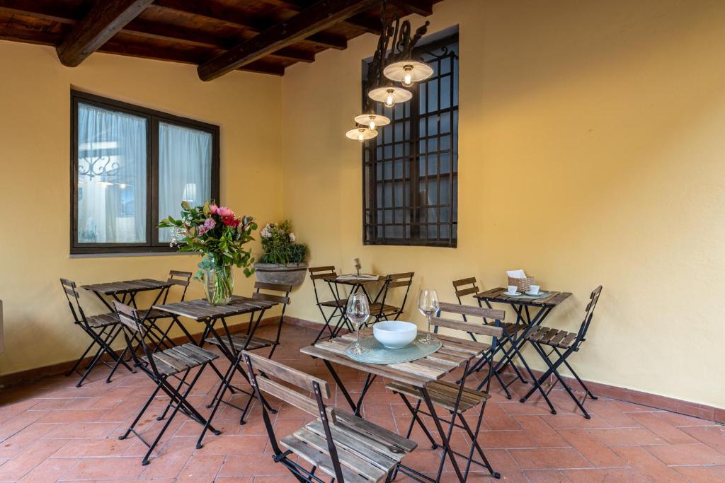 a dining room with tables and chairs and flowers at Cortile Santa Monaca in Florence