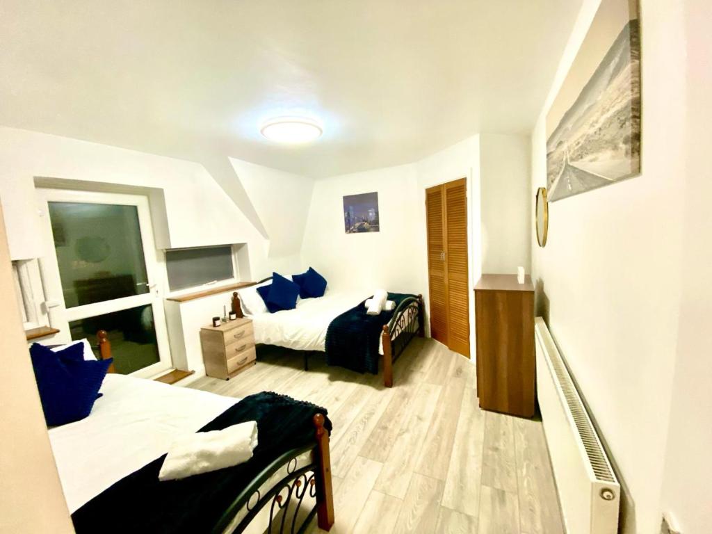 a bedroom with two beds with blue pillows at Cozy One Bedroom Apartment With Free Car Park In London in London