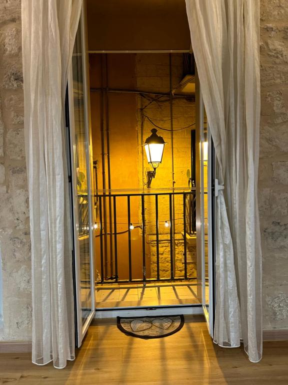 a room with a balcony with curtains and a lamp at Appartamento D'epoca in Bari