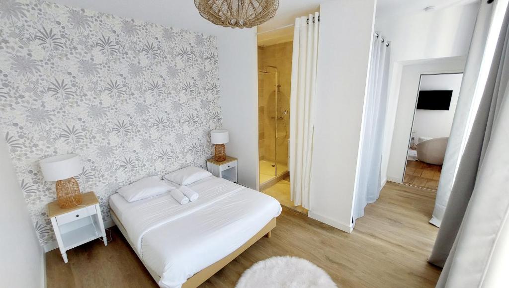 a bedroom with a white bed and a wall at Hyper-centre de Grenoble, suite parentale - wifi fibre - cocon in Grenoble