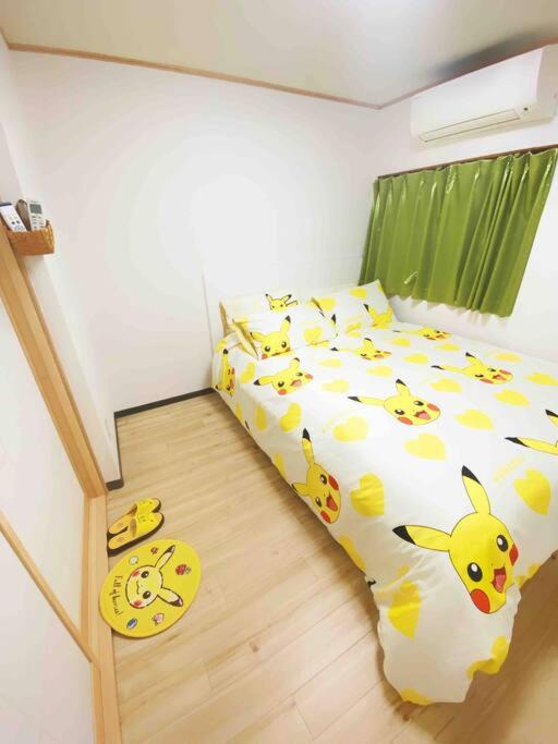 a bedroom with a bed with yellow and white pillows at Pokémon Sleep 宝可梦的家 in Osaka