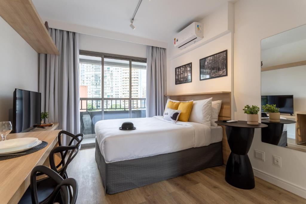 ein Hotelzimmer mit einem Bett und einem Esstisch in der Unterkunft Smart Charlie Parque Augusta Mackenzie in São Paulo