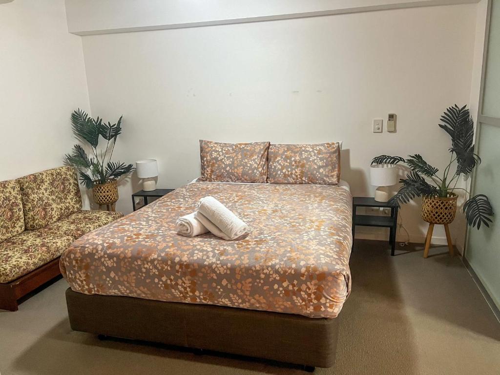 Pavillion on Brookes في بريزبين: غرفة نوم عليها سرير وفوط