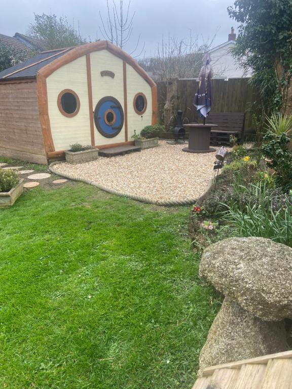 a backyard with a dog house in the yard at Tyluna Cornish Cabin in Praze an Beeble