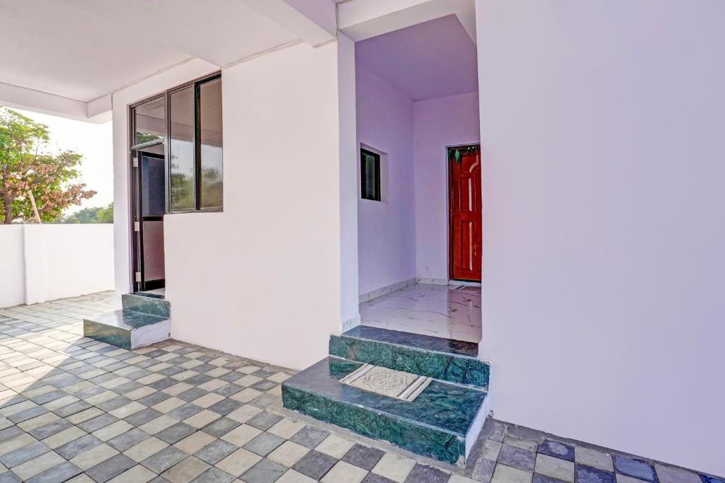 um quarto com uma porta vermelha e piso em azulejo em OYO Hotel R R em Nagpur