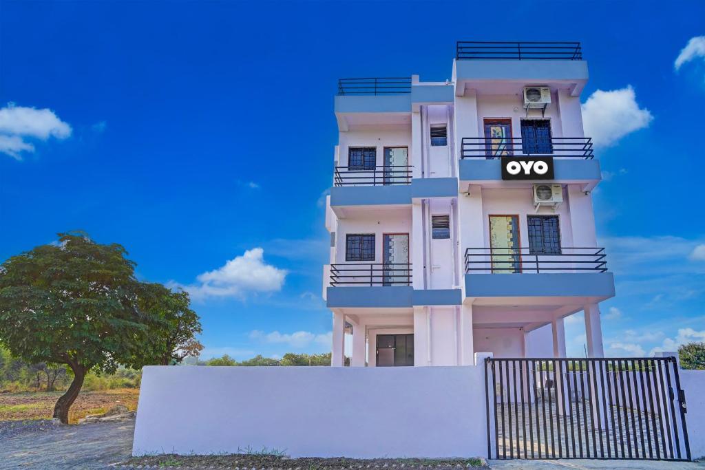 a tall white building with an ocor sign on it at OYO Hotel R R in Nagpur