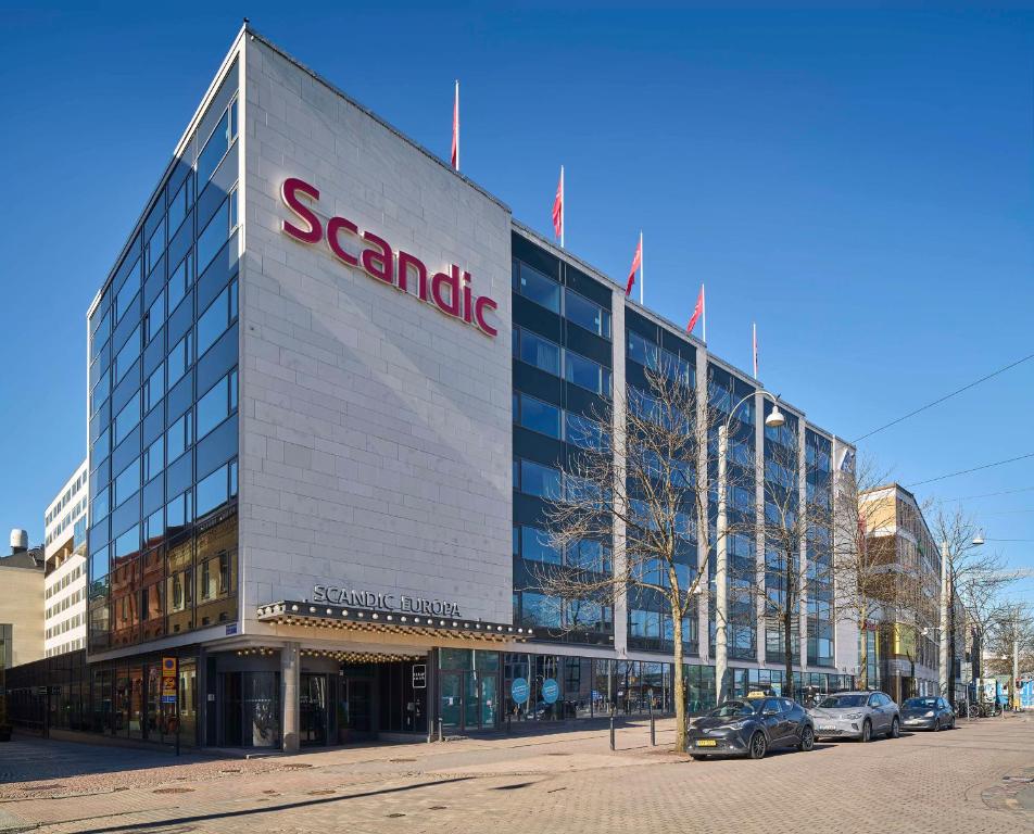 um edifício Sears com carros estacionados em frente em Scandic Europa em Gotemburgo