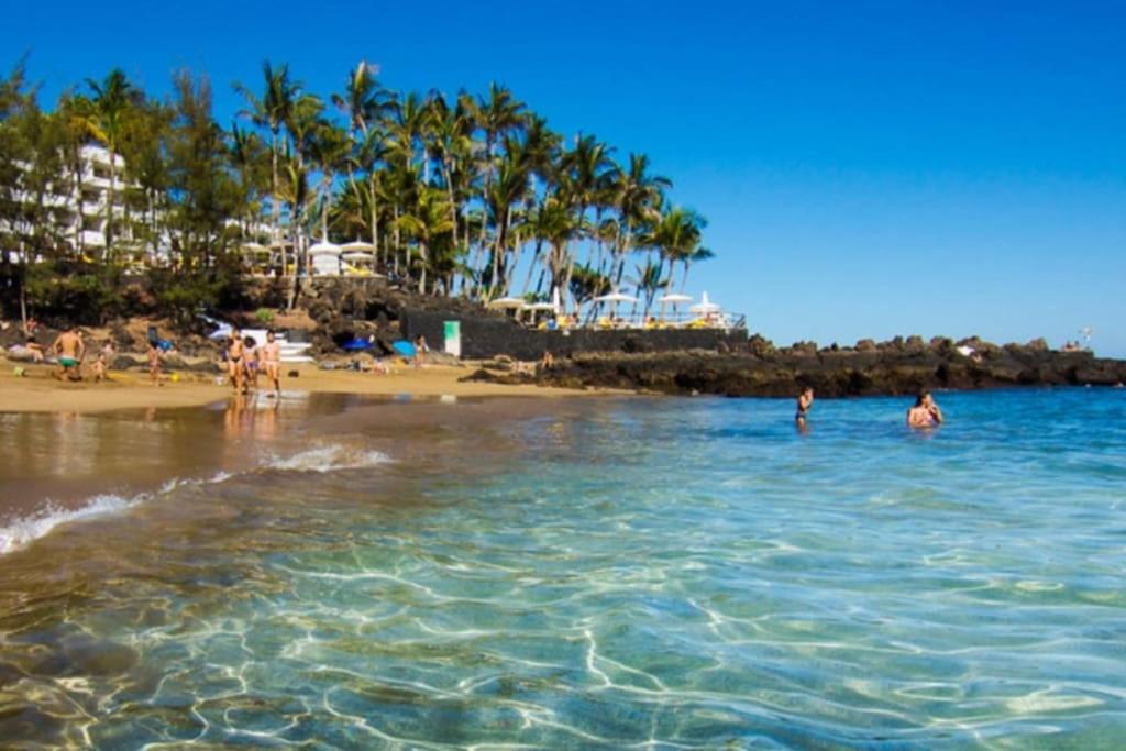 a group of people in the water at the beach at Central Flat Puerto del Carmen in Puerto del Carmen