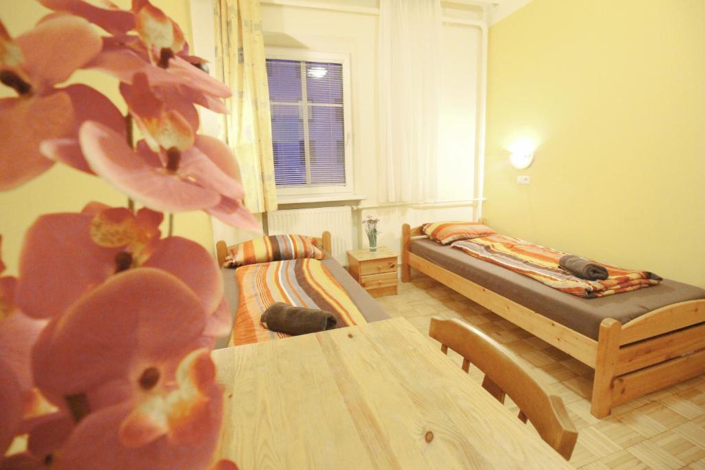 a room with two beds and a table in it at Double Room in Hütteldorfer Straße Area in Vienna