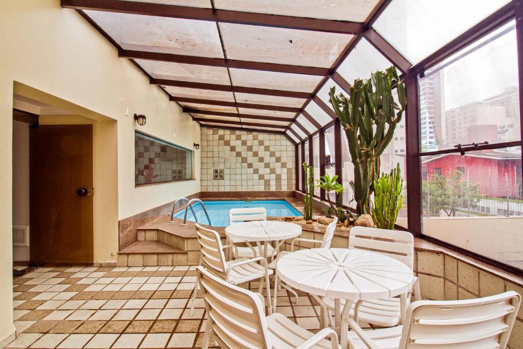 un patio con mesas y sillas y una piscina en NewCiti Itaim by Charlie en São Paulo