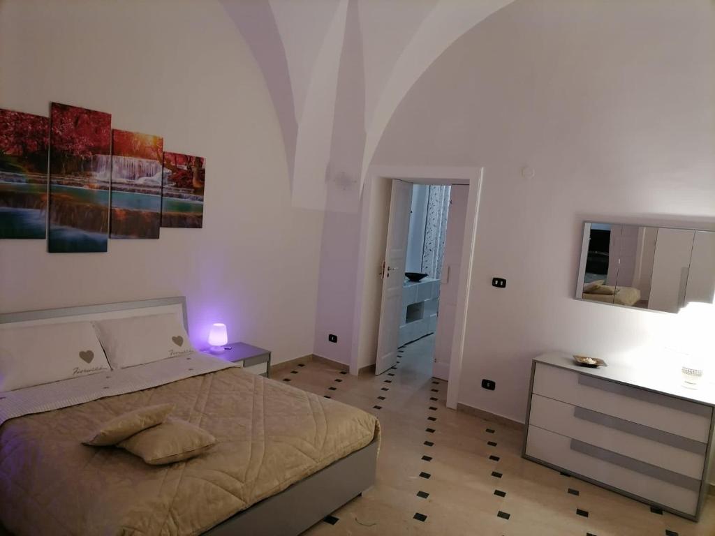 Un dormitorio con una cama y una mesa con una vela en Lips House, en Gravina in Puglia