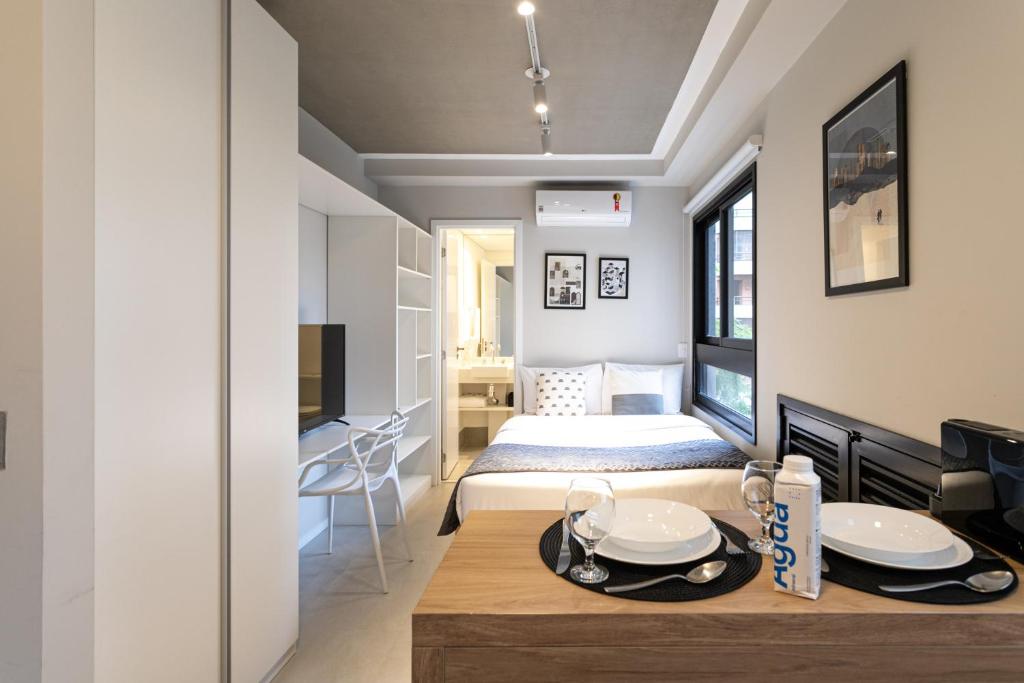 um pequeno apartamento com uma cama e uma mesa de jantar em Charlie Itaim Bueno Brandão em São Paulo