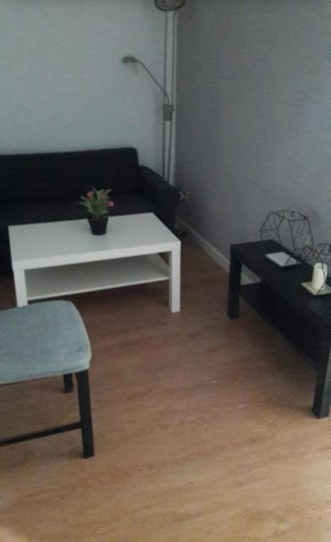 a living room with a black couch and a white coffee table at Apartamento 3 Dormitorios en Sanchez Preciados in Madrid