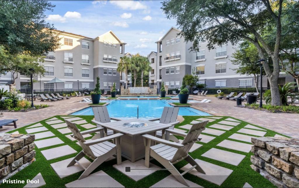 a patio with a table and chairs next to a pool at Hidden Gem at Med Center 2BR & 2BA Apartment in Houston