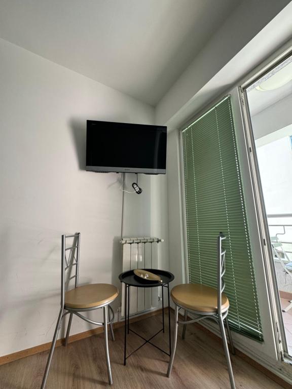 een kamer met 2 stoelen en een flatscreen-tv bij Calvin Apartment 9 in Ohrid