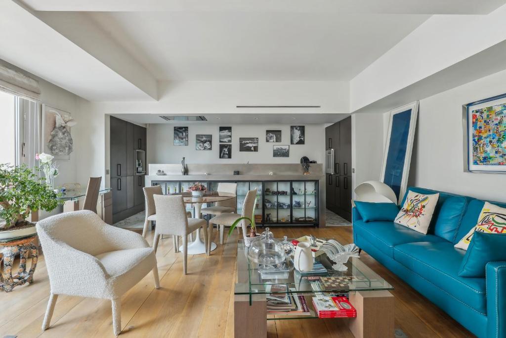 a living room with a blue couch and a table at Quai des Célestins 2bdr in Paris
