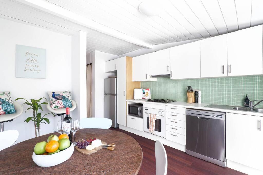 eine Küche mit einem Tisch und einer Obstschale darauf in der Unterkunft Comfy House Sydney Darling Harbour ICC Chinatown in Sydney