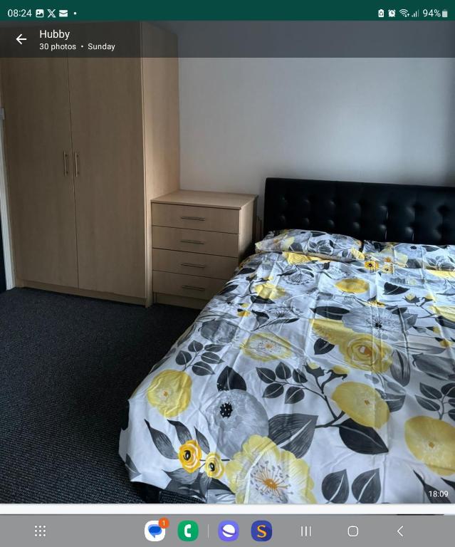 um quarto com uma cama com colcha floral em Northampton town em Kingsthorpe