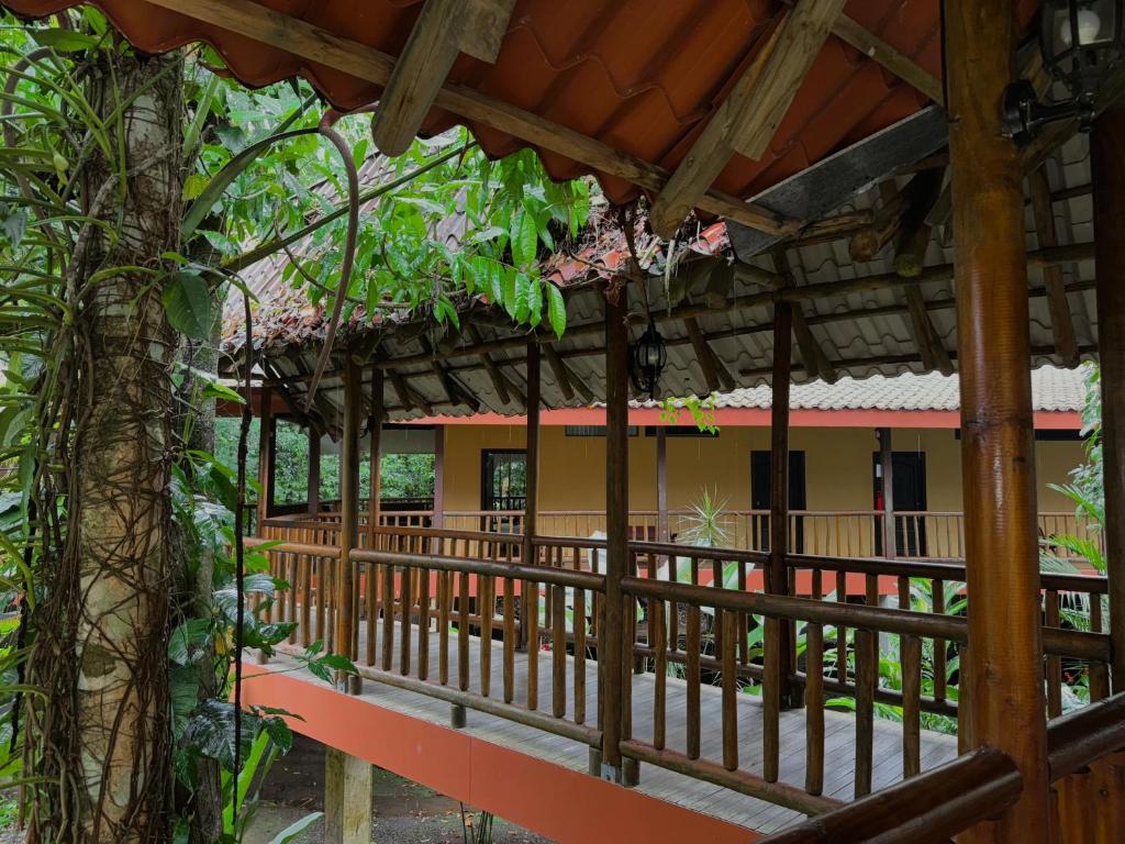 une vue extérieure d'un bâtiment avec une clôture et des arbres dans l'établissement Hotel El Bambu, à Sarapiquí