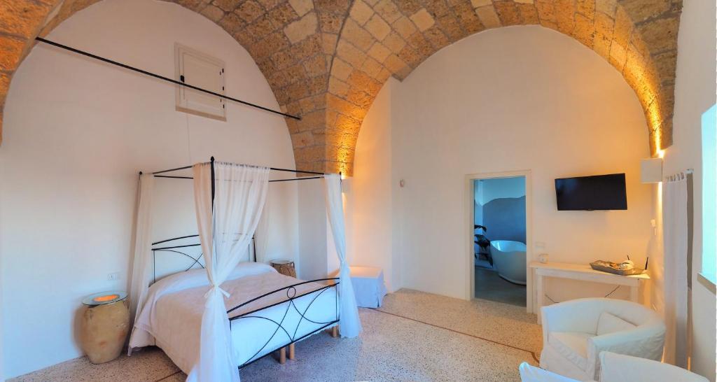 um quarto com uma cama de dossel num quarto em Holiday home La Corte dei Pirri em Gagliano del Capo
