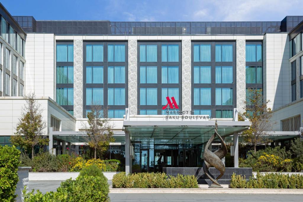 an office building with a sculpture in front of it at Baku Marriott Hotel Boulevard in Baku