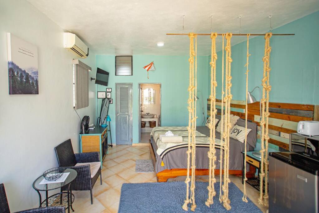 a bedroom with a bed with a hanging bed frame at Studio Apartment Center of Sosua close to Beach with Pool View in Sosúa